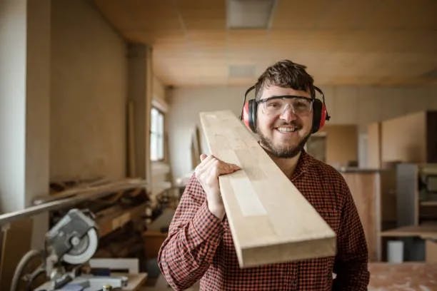 Handyman carrying wood
